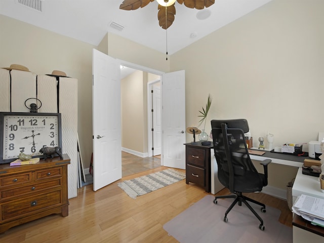 office area featuring baseboards, visible vents, ceiling fan, and light wood finished floors