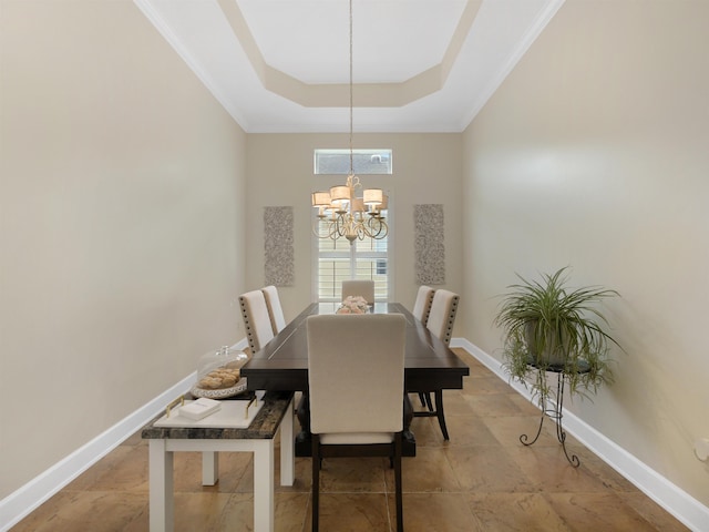 dining space with an inviting chandelier, a raised ceiling, and baseboards