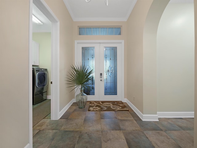 foyer with washer / dryer, baseboards, arched walkways, crown molding, and french doors