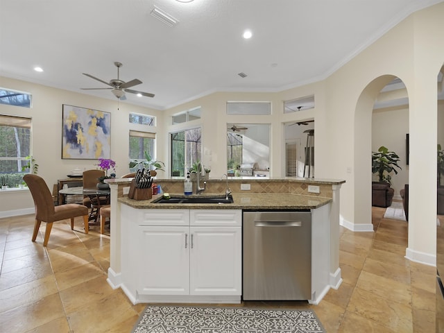 kitchen featuring a center island with sink, white cabinets, dishwasher, dark stone countertops, and a sink