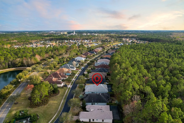 aerial view at dusk featuring a water view and a residential view