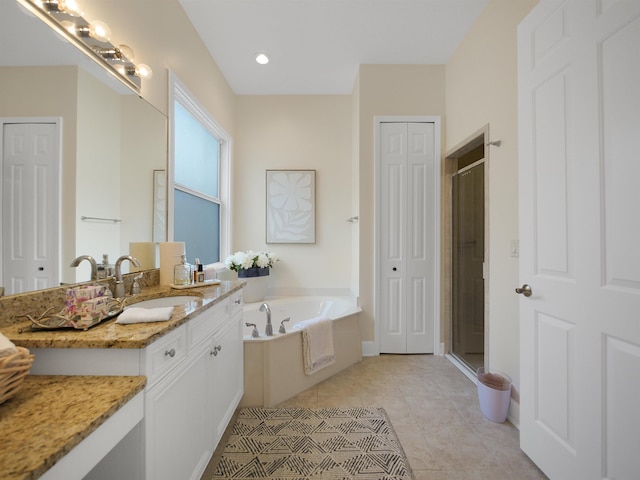 bathroom featuring a garden tub, vanity, a closet, tile patterned floors, and a stall shower