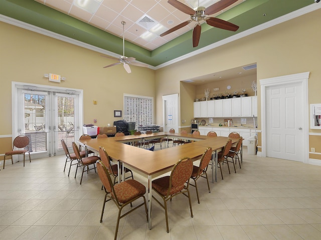 dining room with light tile patterned floors, a raised ceiling, visible vents, a towering ceiling, and baseboards