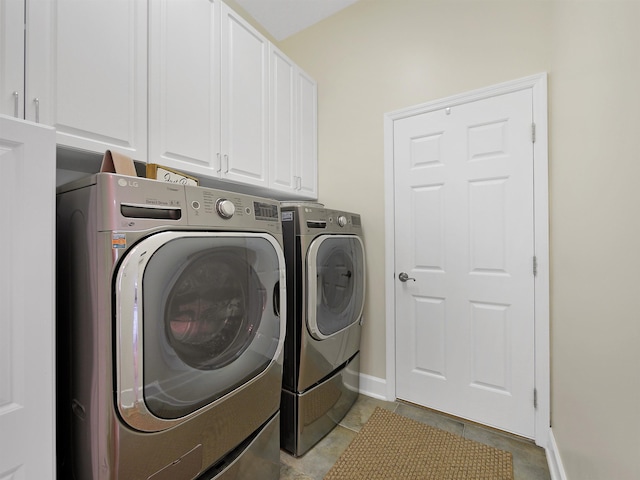 laundry room with cabinet space, baseboards, and independent washer and dryer