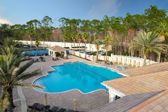 pool with a community hot tub, fence, and a patio