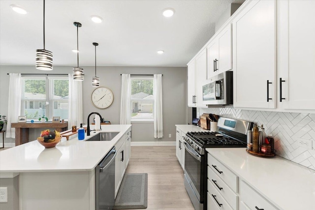 839 Lightsey Crossing Ln, Saint Augustine, FL 32084 - kitchen with stainless steel appliances, light wood-type flooring, backsplash, an island with sink, and light countertops