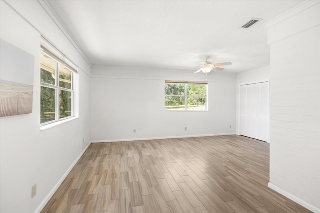 spare room with ceiling fan, plenty of natural light, and light hardwood / wood-style floors