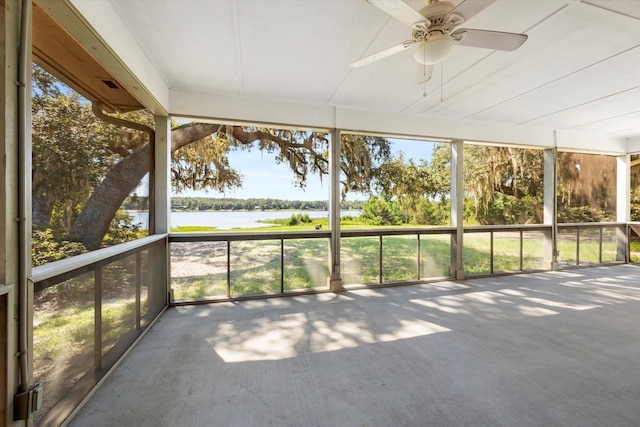 unfurnished sunroom featuring ceiling fan, a healthy amount of sunlight, and a water view