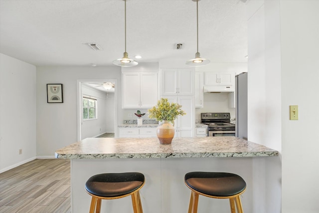 kitchen featuring white cabinetry, ceiling fan, stainless steel appliances, pendant lighting, and light wood-type flooring