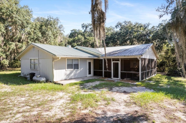 rear view of house with a sunroom and a yard