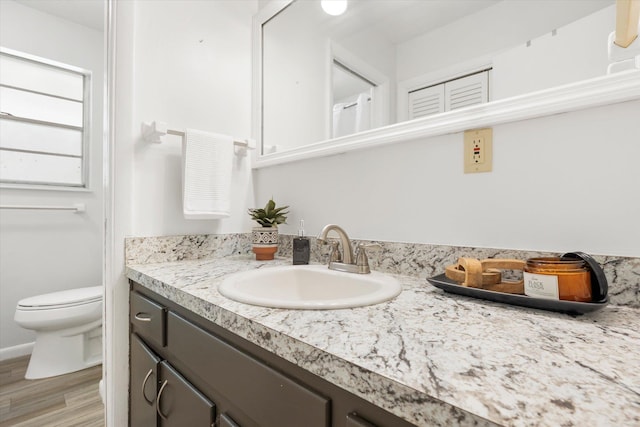 bathroom featuring hardwood / wood-style floors, vanity, and toilet