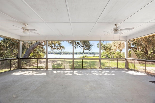 unfurnished sunroom featuring ceiling fan, a healthy amount of sunlight, and a water view