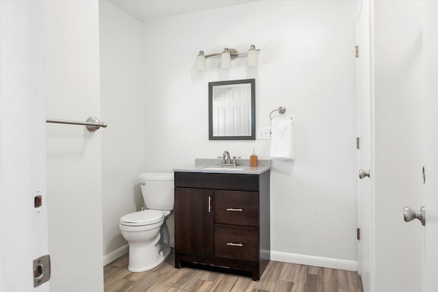 bathroom with hardwood / wood-style floors, vanity, and toilet