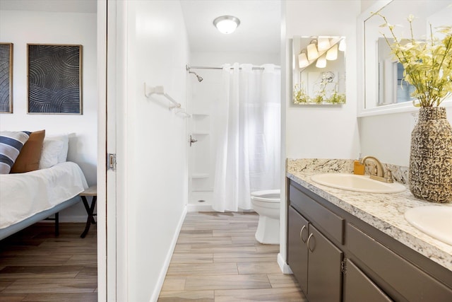 bathroom featuring a shower with shower curtain, vanity, hardwood / wood-style flooring, and toilet