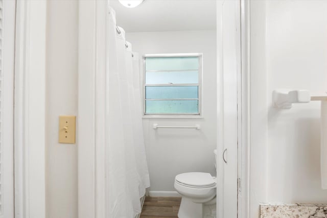 bathroom featuring hardwood / wood-style flooring and toilet