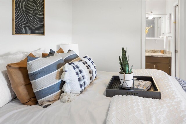 bedroom featuring ensuite bathroom and sink