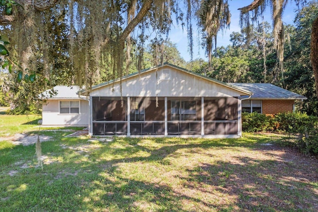 back of house featuring a sunroom and a yard