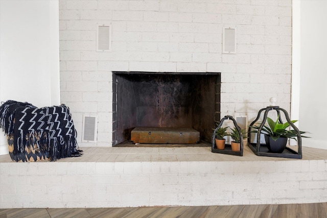 details with wood-type flooring and a brick fireplace