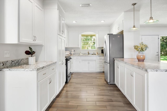 kitchen with white cabinets, stainless steel fridge, black electric range oven, and pendant lighting