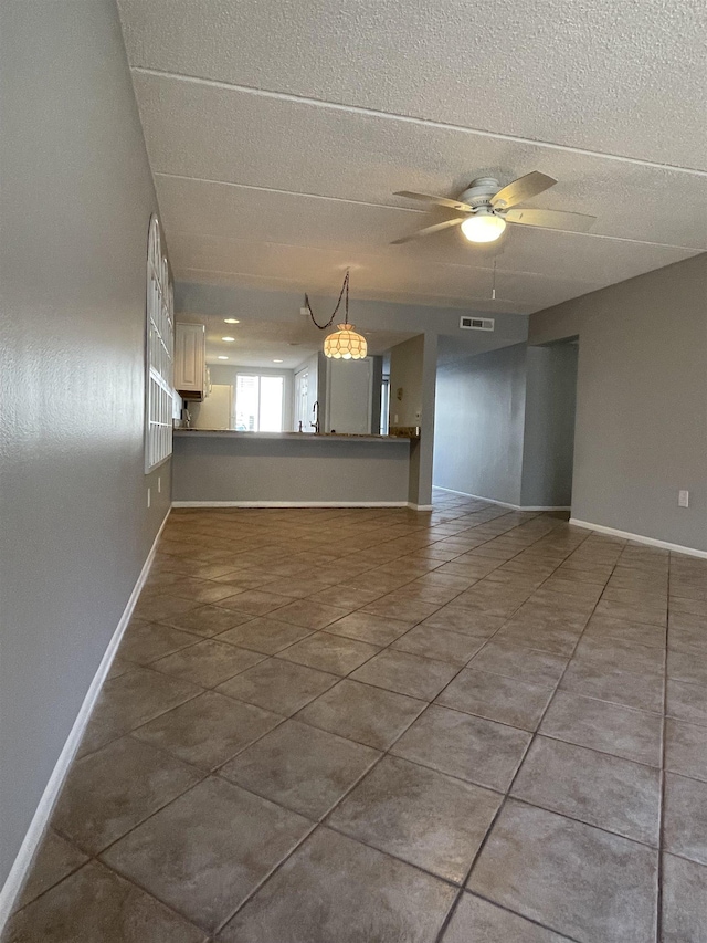 8130 A1A S Unit D-2, Saint Augustine, FL 32080 - empty room featuring tile patterned floors, visible vents, a ceiling fan, a textured ceiling, and baseboards