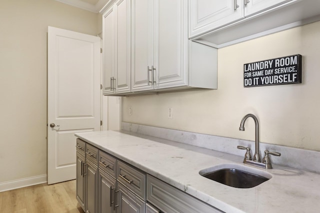 104 Fiddler Crab Ln, Saint Augustine, FL 32080 - kitchen featuring light stone counters, light wood-style floors, gray cabinetry, and white cabinets