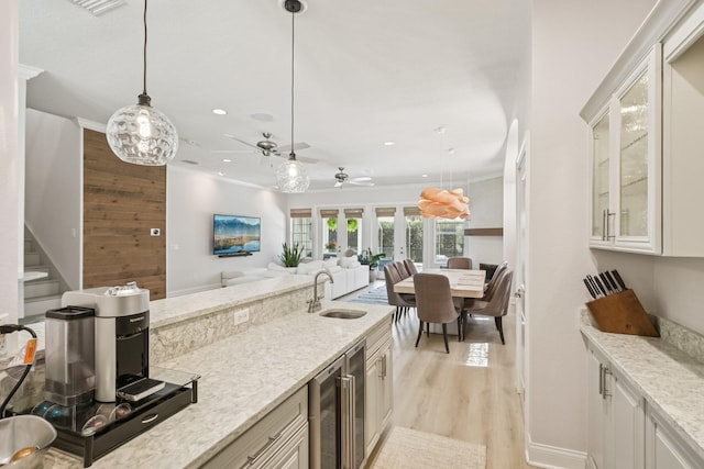 104 Fiddler Crab Ln, Saint Augustine, FL 32080 - kitchen featuring wine cooler, hanging light fixtures, recessed lighting, light wood-style floors, and light stone counters