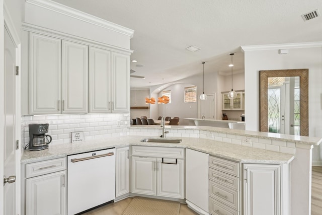104 Fiddler Crab Ln, Saint Augustine, FL 32080 - kitchen featuring white dishwasher, a peninsula, decorative backsplash, white cabinets, and ornamental molding