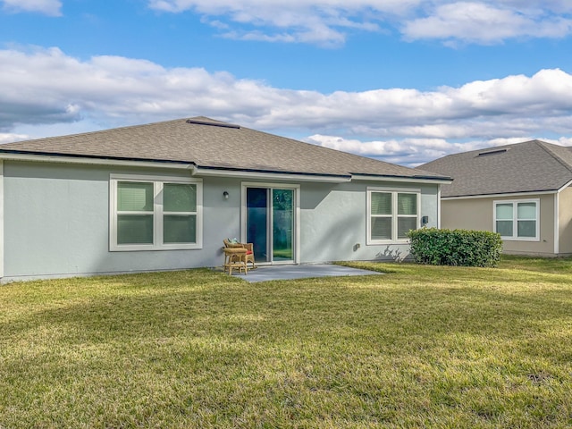 back of property with a yard and a patio