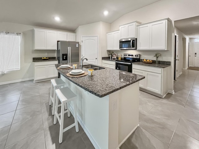 kitchen with white cabinetry, sink, an island with sink, lofted ceiling, and appliances with stainless steel finishes