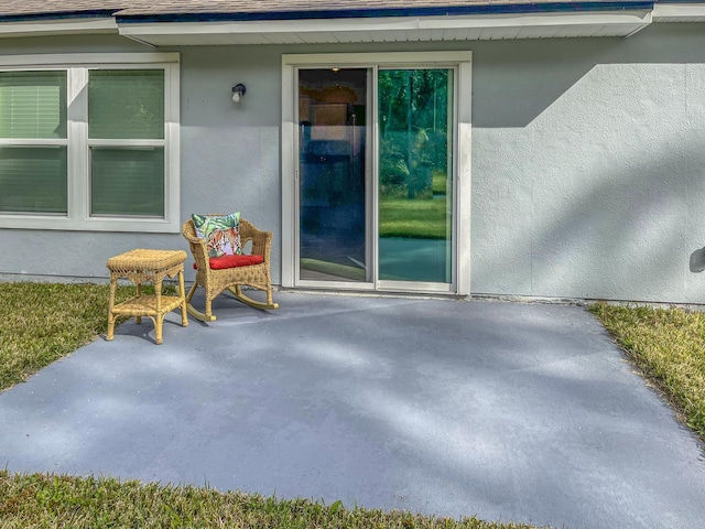 view of exterior entry with a patio