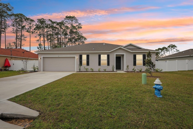 ranch-style home featuring stucco siding, driveway, fence, a yard, and a garage