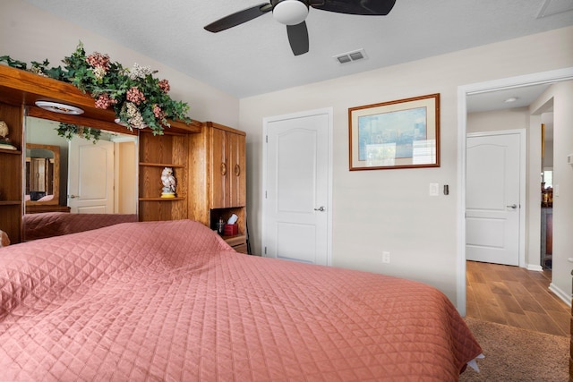 bedroom with ceiling fan and a textured ceiling