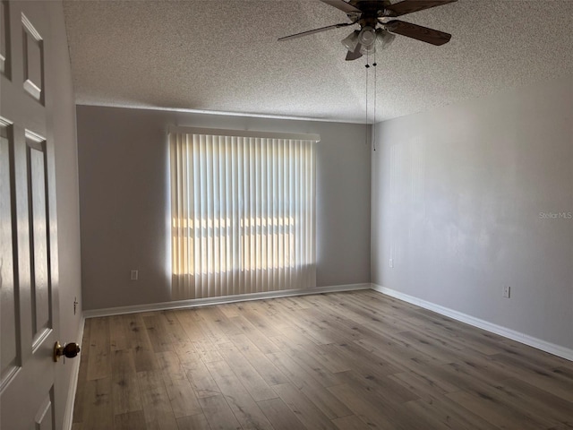 unfurnished room with baseboards, a textured ceiling, ceiling fan, and wood finished floors