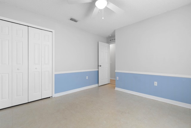 unfurnished bedroom featuring a closet, visible vents, a textured ceiling, and baseboards