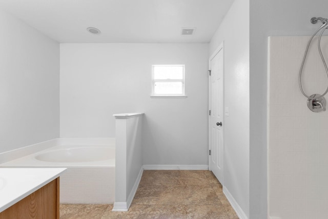 bathroom featuring vanity, a bathtub, visible vents, and tiled shower