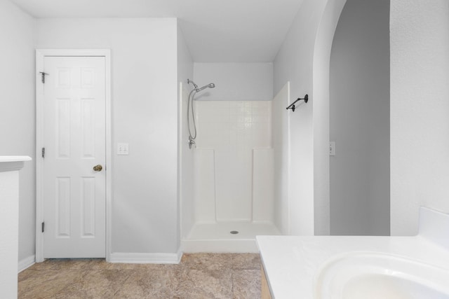 full bathroom with a shower, baseboards, and vanity