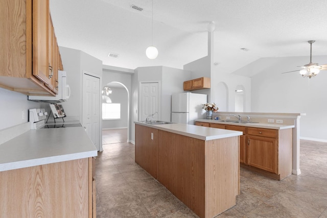 kitchen featuring a sink, electric range, arched walkways, and freestanding refrigerator