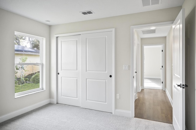 unfurnished bedroom featuring a closet and light wood-type flooring