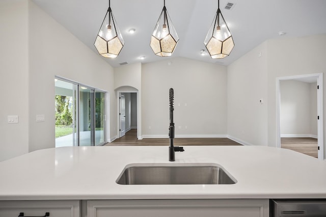 kitchen featuring decorative light fixtures, a kitchen island with sink, lofted ceiling, and sink