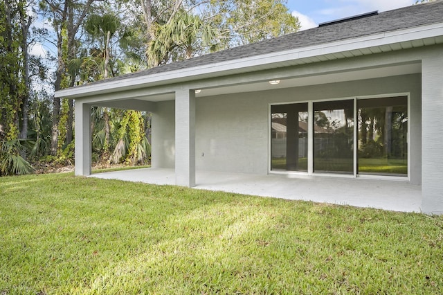 back of house with a yard and a patio