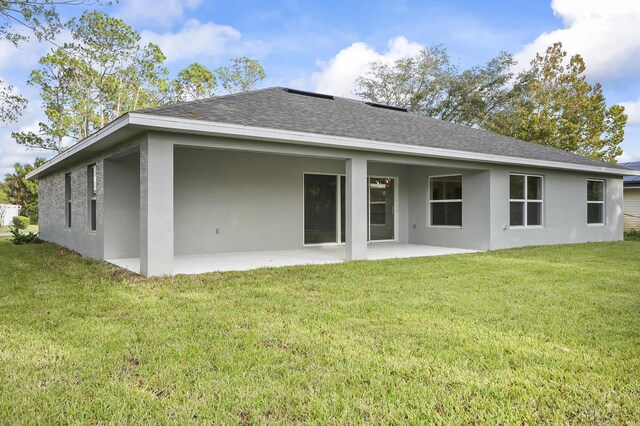 back of property featuring a patio and a lawn