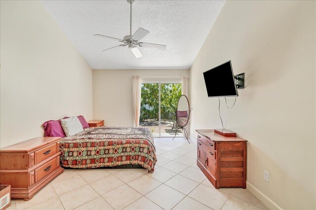 tiled bedroom with access to exterior, a textured ceiling, vaulted ceiling, and ceiling fan