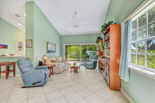 tiled living room featuring ceiling fan, a healthy amount of sunlight, and vaulted ceiling