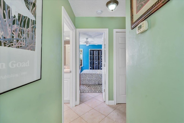 hallway with light tile patterned floors and a textured ceiling