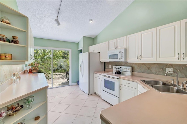 kitchen featuring sink, a textured ceiling, lofted ceiling, white appliances, and white cabinets