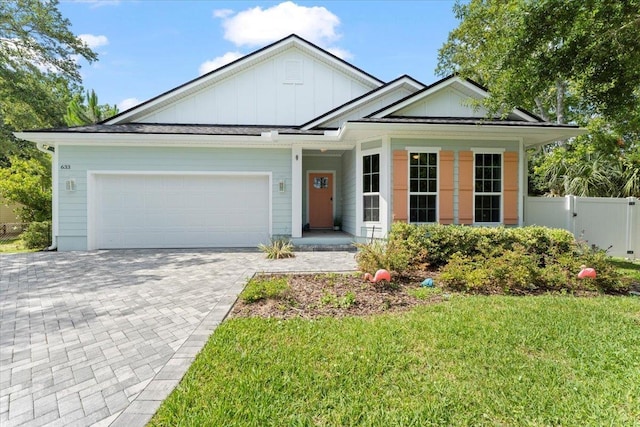 633 W Pope Rd, Saint Augustine, FL 32080 - view of front of house with board and batten siding, an attached garage, and decorative driveway