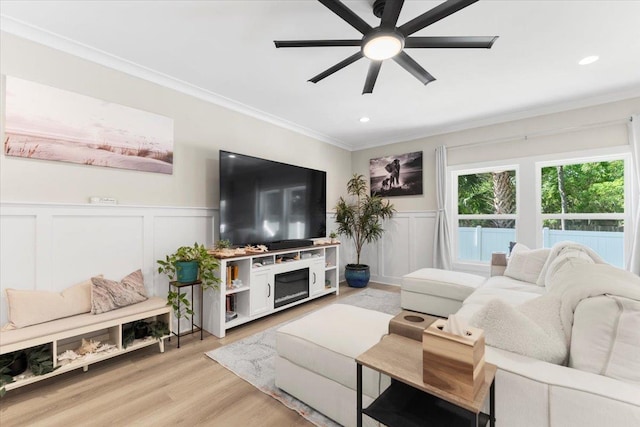 633 W Pope Rd, Saint Augustine, FL 32080 - living area with crown molding, a ceiling fan, a decorative wall, light wood finished floors, and a wainscoted wall
