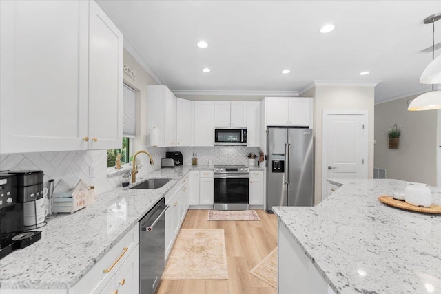 633 W Pope Rd, Saint Augustine, FL 32080 - kitchen featuring stainless steel appliances, ornamental molding, light wood-style flooring, white cabinets, and decorative backsplash