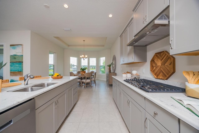 kitchen featuring gray cabinetry, sink, an inviting chandelier, pendant lighting, and appliances with stainless steel finishes