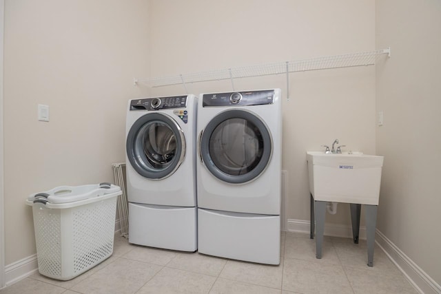 laundry room featuring independent washer and dryer and light tile patterned floors